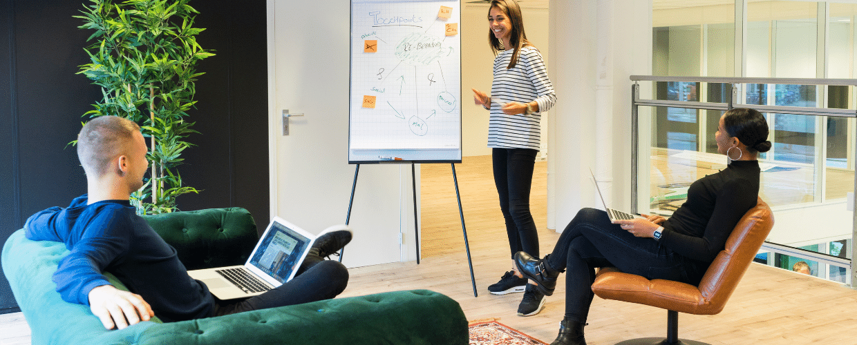 Three people are having a casual meeting in a modern office space.